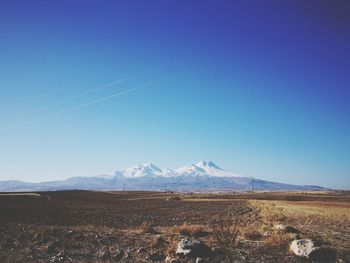 Scenic view of snowcapped mountains against clear blue sky