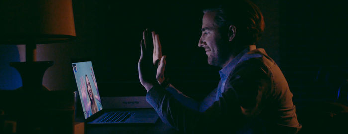 Side view of man doing video conference on laptop