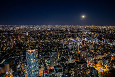 Illuminated cityscape against sky at night