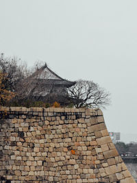 Low angle view of stone wall against clear sky