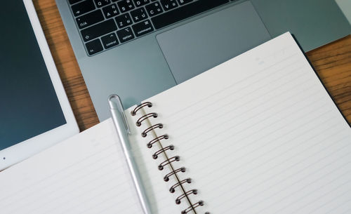 High angle view of laptop and book on table