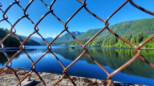 Scenic view of lake seen through chainlink fence