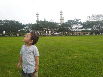 Boy standing on grassy field