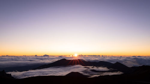 Scenic view of snowcapped mountains against sky during sunset