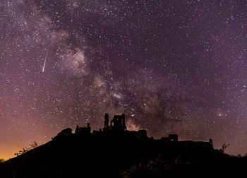 Low angle view of silhouette buildings against sky at night