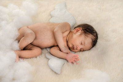 High angle view of naked baby boy sleeping on bed