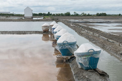 White salt in basket at salt evaporation pond farm in mae klong, samut songkhram, thailand.