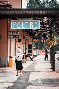 Rear view of people walking on street in city