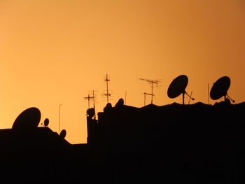 Low angle view of silhouette houses against sky during sunset