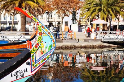 Colorful boat moored in river against buildings