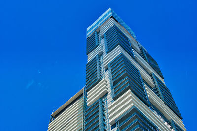 Low angle view of modern building against clear blue sky