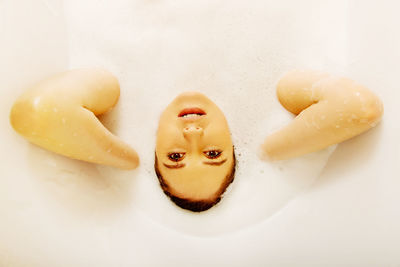 Portrait of young woman taking bath in bathtub at bathroom