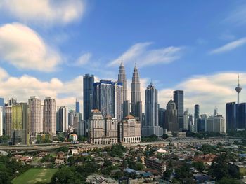 Buildings in city against cloudy sky