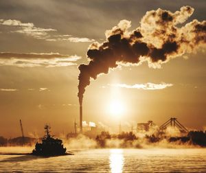 Silhouette of smoke stack at sunset