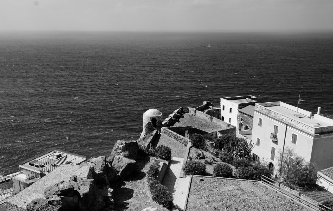 HIGH ANGLE VIEW OF HISTORIC BUILDING AGAINST SEA