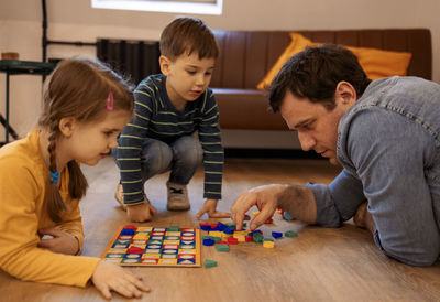 High angle view of mother playing with toy blocks at home