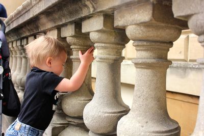 Side view of boy holding balustrade