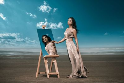 Woman standing on beach against sky