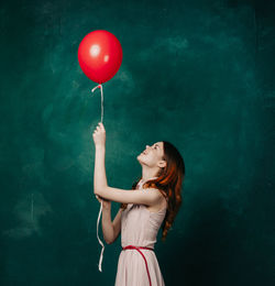 Portrait of woman with red balloon