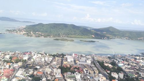 High angle view of city by sea against sky