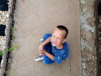 High angle view of boy sitting outdoors