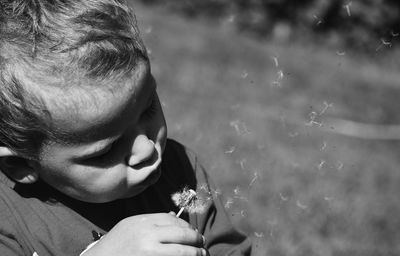 Close-up portrait of boy holding flowers