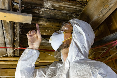 Low angle view of man working on wood