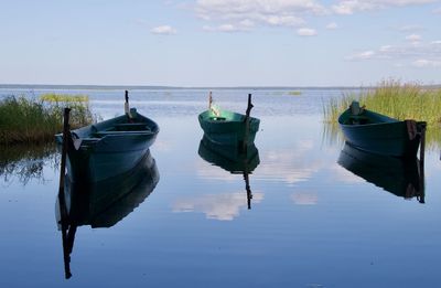 Boats moored in lake against sky