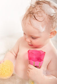 Girl playing with toys in bathtub