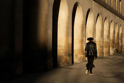 Rear view of man walking in corridor of building