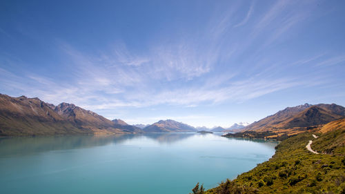 Scenic view of lake and mountains against blue sky