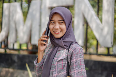 Portrait of young woman standing outdoors