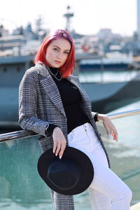 Young woman sitting in boat against canal