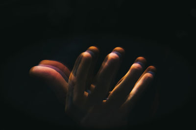 Blurred motion of hand gesturing against black background