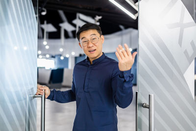 Portrait of young man standing against building