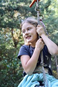 Happy girl sitting on swing