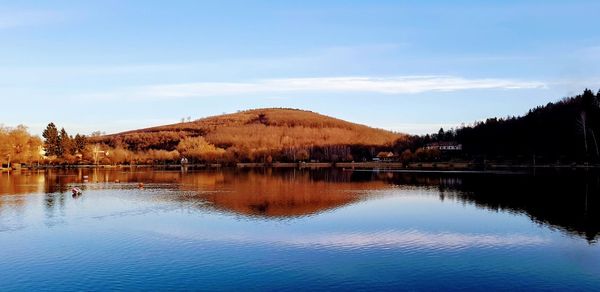 Scenic view of lake by trees against sky