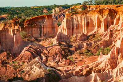 Tourists dwarfed by the rock formations at marafa depression - hell's kitchen at sunset in kenya