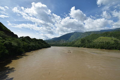 Scenic view of river amidst mountains against sky