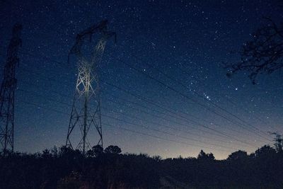 Low angle view of silhouette trees against sky at night