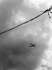 Low angle view of silhouette airplane flying in sky