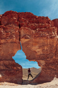 Full length of woman standing amidst rock formation on landscape