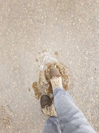 Low section of person standing in puddle