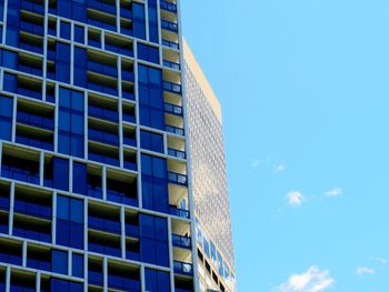 Low angle view of modern building against blue sky