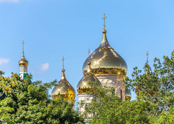 Temple by building against clear blue sky