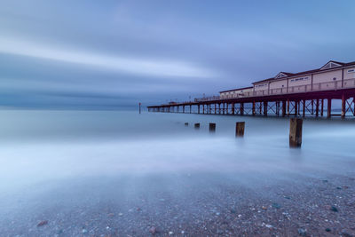 Pier over sea against sky at dusk