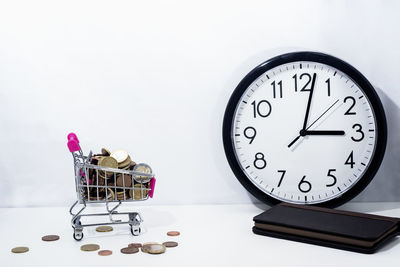 Close-up of clock on table against wall