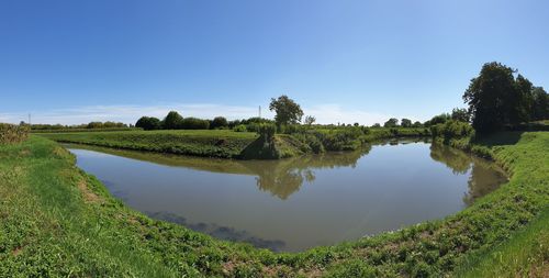 Scenic view of lake against clear blue sky