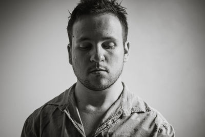 Close-up of thoughtful young man against gray background