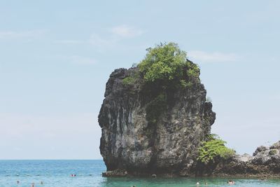 Rock formation by sea against sky